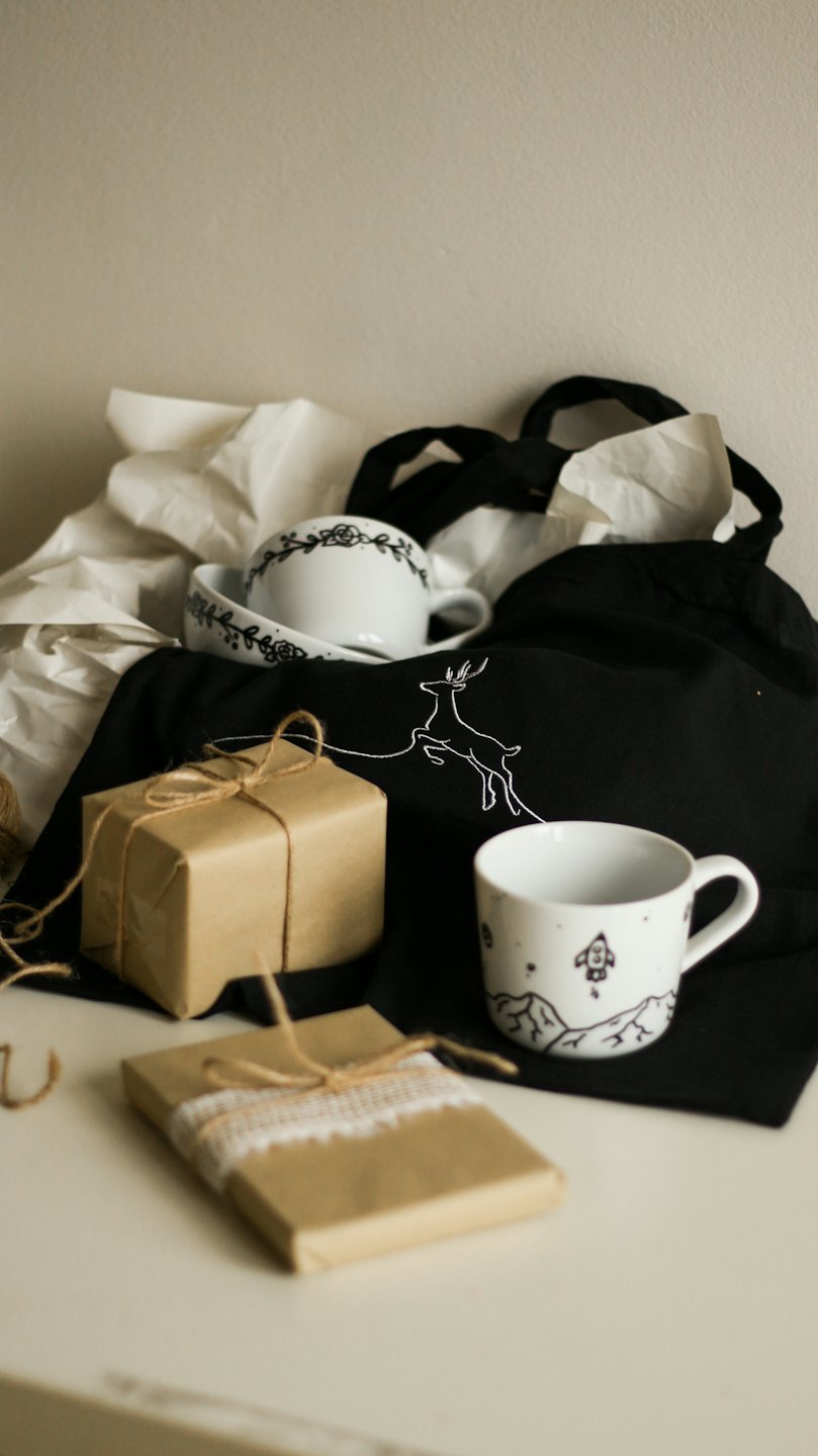 Artisanal gifts and mugs arranged on a white surface.
