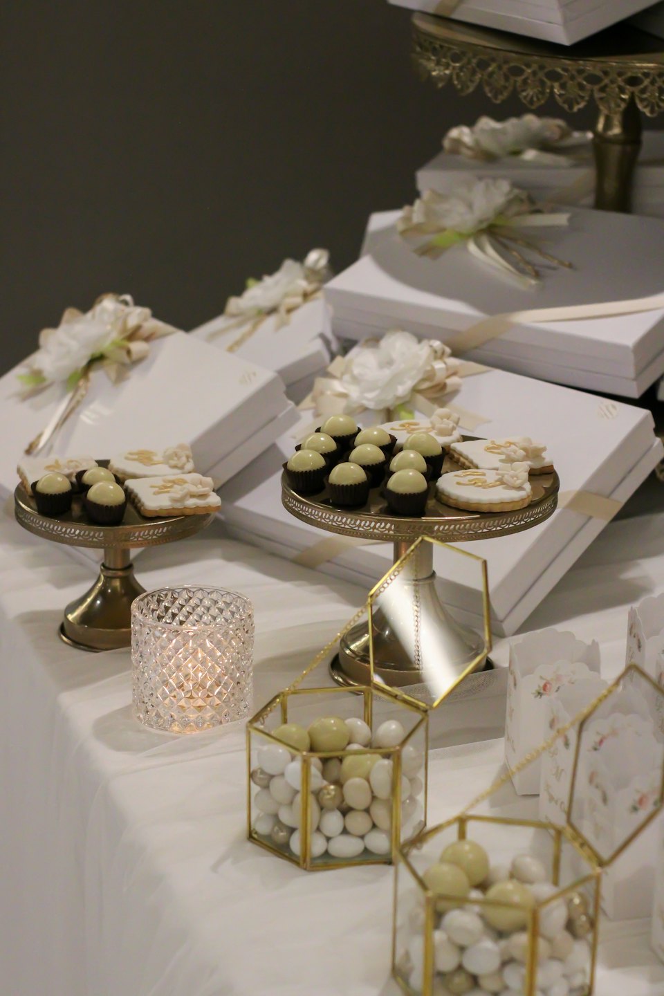 Elegant event display featuring gift boxes, chocolate truffles, and candles.