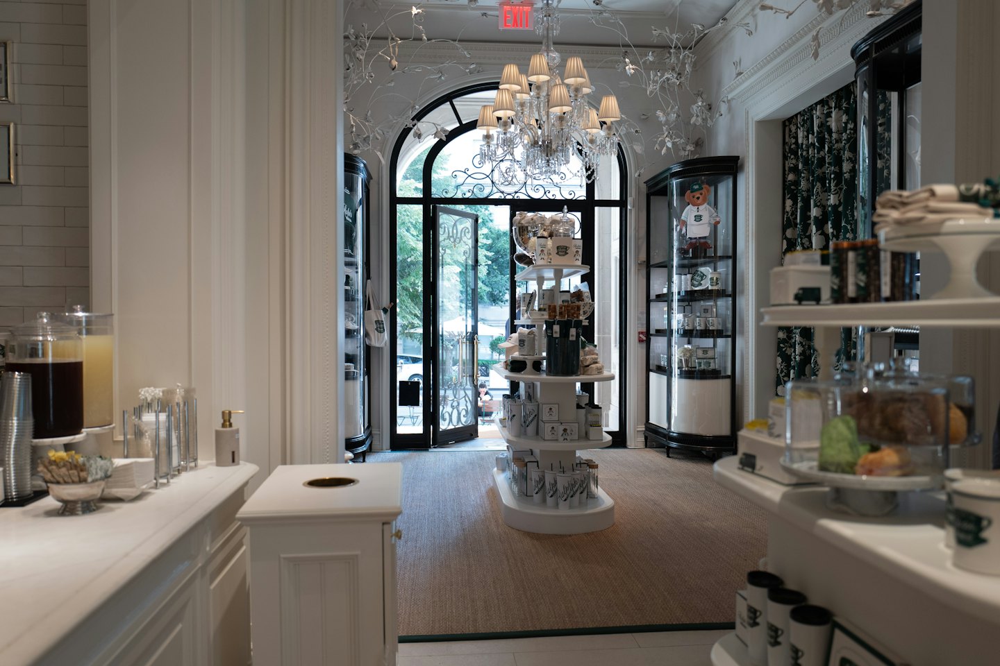 Elegant boutique entrance with arched doorway and chandelier.